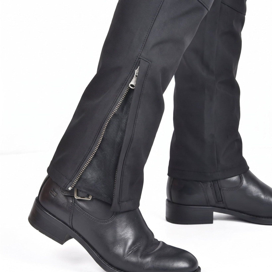 Close-up of a zipped ankle cuff on black NORDRYK RoadVault trousers, worn over a boot