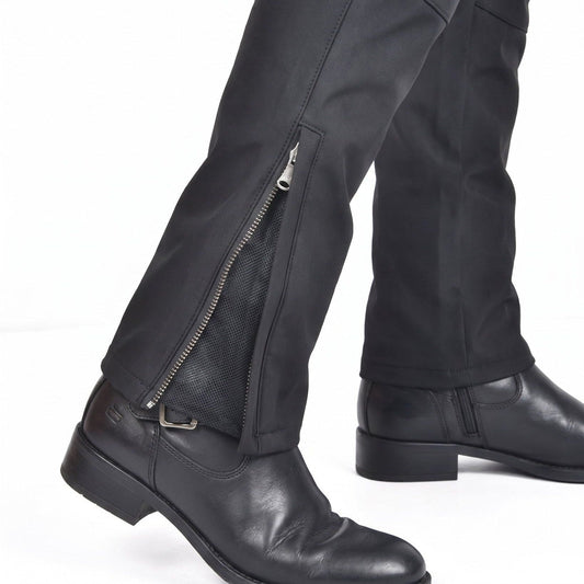 Close-up of a zipped ankle cuff on black NORDRYK RoadVault trousers, worn over a boot