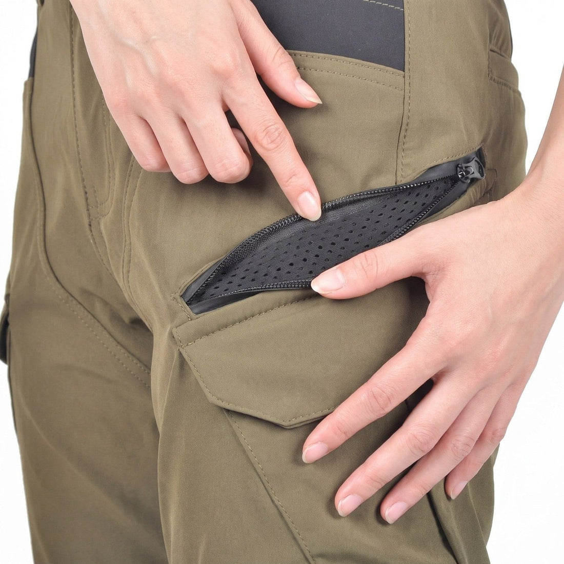 Close-up of hands opening a mesh-vented zip pocket on olive green NORDRYK RoadVault cargo trousers