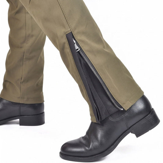 Olive riding trousers with the ankle zip and black mesh panel open over a black leather boot, shown mid-step on a white background